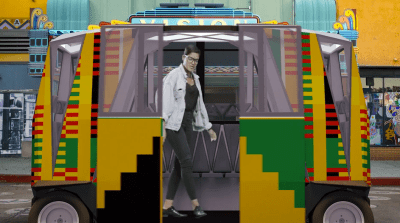 A visitor alights from an autonomous micro shuttle in front of the Vision Theater. Screenshot from video produced by Karl Baumann and Ben Caldwell.