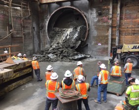 Construction crews look on as the Regional Connector Tunnel Boring Machine breaks through at Grand Avenue station. The circular TBM face is visible behind the tunnel rubble. All photos by Joe Linton/Streetsblog L.A.