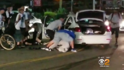 Cyclists removing driver from car. Screen capture from CBS