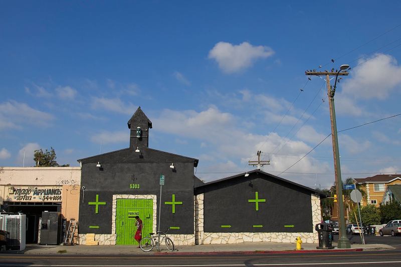 A young man walks past a church that was recently converted into a weed shop on Broadway in South L.A. Sahra Sulaiman/Streetsblog L.A.