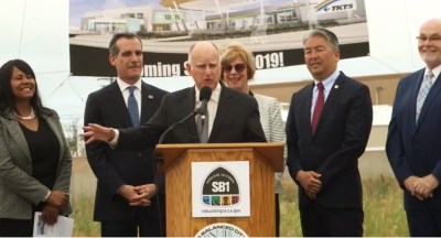 Governor Brown touting the benefits of CA's gas tax increase. Left to right are: Torrance Transit head Kim Turner, L.A. Mayor Eric Garcetti, Governor Jerry Brown, Supervisor Janice Hahn, Assemblymember Al Muratsuchi, and Torrance Mayor Patrick Furey. Screen capture via Muratsuchi Facebook video