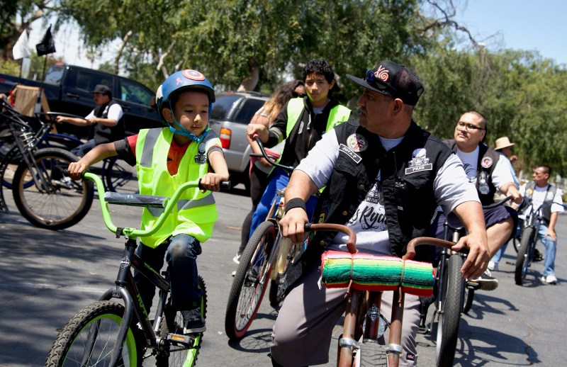 Javier "JP" Partida talks to 7-year-old Sammy, son of a childhood friend and one of the next generation of riders Partida hopes his club, Los Ryderz, can reclaim streets for. Sahra Sulaiman/Streetsblog L.A.