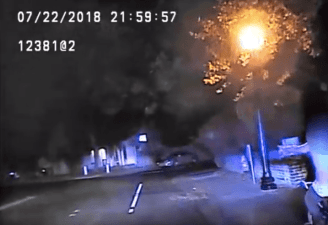 Teen on bike (lower right of image) signals to police just before getting pulled over. Screengrab from police dash-cam footage.