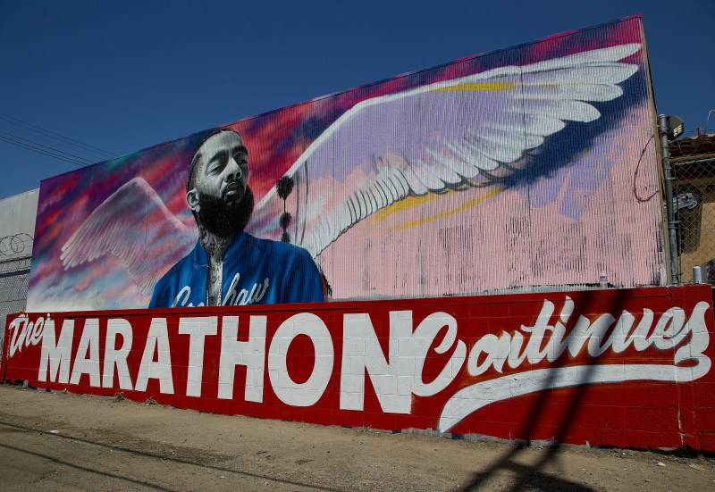A portrait of Nipsey Hussle by artist Danny Mateo graces the alley adjacent to the strip mall where Nipsey Hussle was killed at Crenshaw and Slauson on March 31. "The Marathon Continues" references both his approach to building his career from the ground up and his understanding of what it took to bring the community along with him. Sahra Sulaiman/Streetsblog L.A.