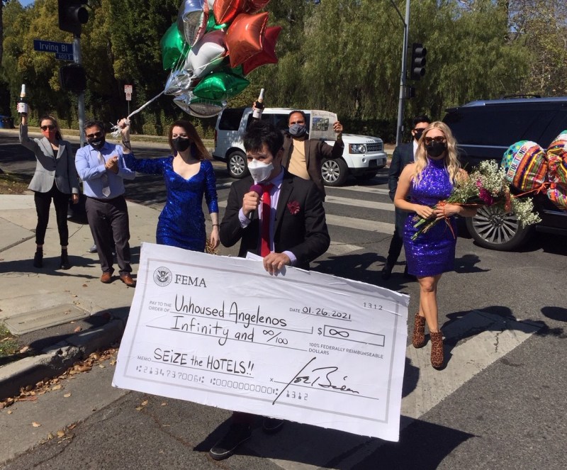 KItown for All presenting a large check mocking the city's inability to take broad advantage of federal funding for Project Roomkey. Photos by Joe Linton