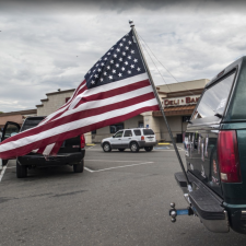 Image description: an American flag attached to the bumper of a large SUV. Source: Robert Couse-Baker, PxHere, CC