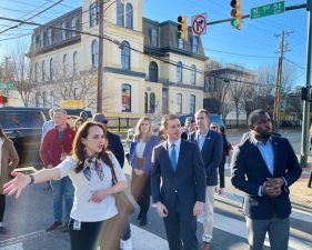 U.S. Transportation Secretary Pete Buttigieg, center, takes a tour of Richmond’s Jackson Ward Neighborhood, accompanied by Mayor Levar Stoney (right) and Maritza Mercado Pechin, (left) a city planning official. Image courtesy Wyatt Gordon for the Virginia Mercury)