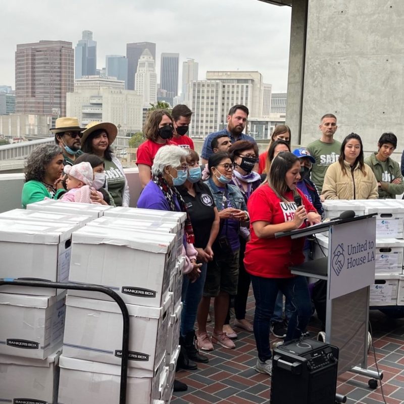 UNITE HERE Local 11 representative Isela Ramos speaking alongside boxes containing over 98 thousand signatures for United to House L.A. - photos by Joe Linton/Streetsblog