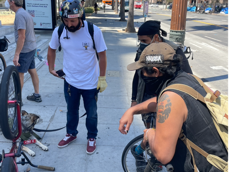 A bike mechanic and his four-legged assistant examine a bicycle in need of repair at a pop-up clinic in front of City Hall's west entrance. Photo: Damien Newton
