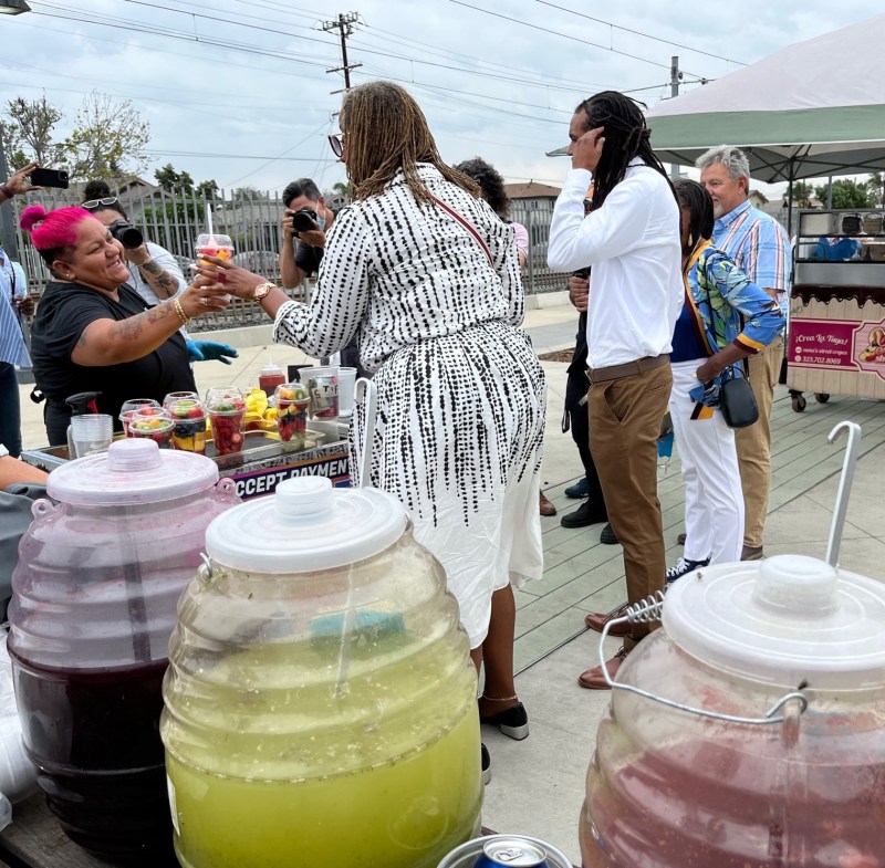 Supervisor Holly Mitchell purchases fruit from a vendor at ACT-LA's Compton Station activation event. Metro Boardmember Fernando Dutra is on the right in a light blue shirt. Photos by Joe Linton/Streetsblog